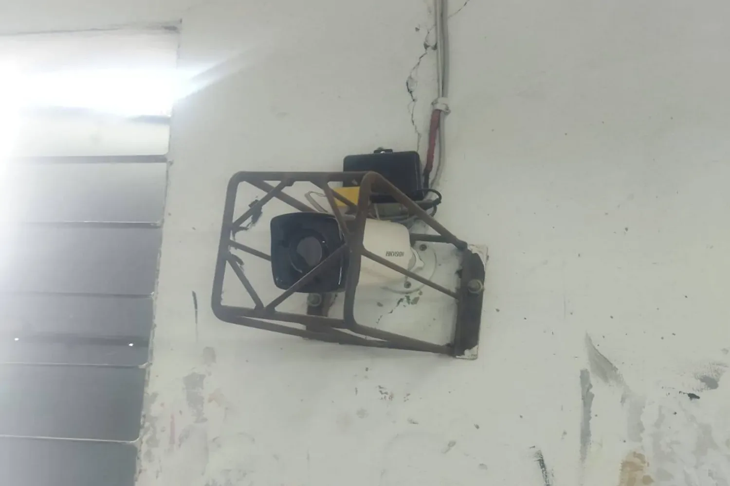 Hikvision CCTV camera installation with protective metal cover on wall for secure surveillance